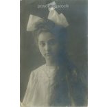 Young girl with long hair with bow. Original paper image. Postcard, photo sheet. 1920s. (2791798)