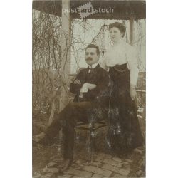   1910 - Full-length photo of husband and wife in the garden. The setting is a bit stiff, revealing a lot about the couple’s relationship. Original paper image. Postcard, photo sheet. (2791994