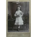 Early 1900s. Photography studio of Sándor Salgó, Budapest. Full-length studio photo. A little girl with a baby in an elegant outfit, with a bow in her hair.  Cabinet card / CDV photo / hardback photo. (2792119)