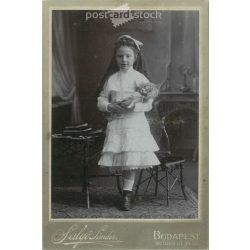   Early 1900s. Photography studio of Sándor Salgó, Budapest. Full-length studio photo. A little girl with a baby in an elegant outfit, with a bow in her hair.  Cabinet card / CDV photo / hardback photo. (2792119)