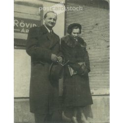   1930s. In the sunshine. Middle-aged couple in front of a haberdashery shop. Original paper image. Its maker is unknown. (2792221)