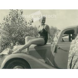   1953 - Germany. Bodensee. Pretty young woman sitting on the car. Its maker is unknown. Black and white original paper image, old photo. (2792425)