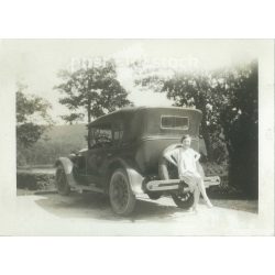   1930s. Germany. Car rest area. Young woman posing sitting on the bumper of the car. Its maker is unknown. Black and white original paper image, old photo. (2792430)