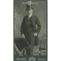   Early 1900s. Studio photo of an elegant man, in a top hat, with a walking stick, full-length. The work of Schmidt Ede photography studio. Budapest. Old photo, original cabinet photo / hardback photo. (2792726)