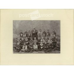   Class photo with charismatic teacher. The people in the photo and the photographer are unknown. Original old photo. Black and white, laminated photo, original paper photo. (2792813)