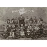 Class photo with charismatic teacher. The people in the photo and the photographer are unknown. Original old photo. Black and white, laminated photo, original paper photo. (2792813)