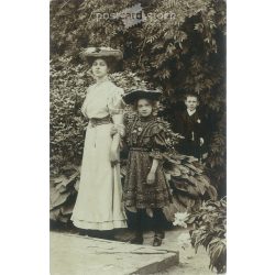   1910s. Young woman with her little daughter and a secret admirer. The people in the picture and the photographer are unknown. Original photo. Black and white photo card, postcard. (2793432)
