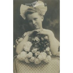   1910s. Little girl with bow and flower. The person in the picture and the photographer are unknown. Original photo. Black and white photo card, postcard. (2793435)