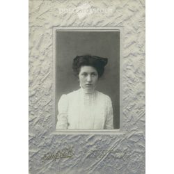   Early 1920s. Young woman in white, with a bow. The picture was taken in the photo studio of Károly Haberfeld. Black and white, laminated old photo, original paper image. (2793608)