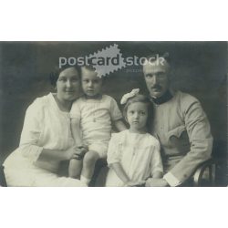   Studio photo of a family of four. The people in the photo and the photographer are unknown. Gelatin silver. Original old photo. Black and white photo card, old postcard. (2793612)