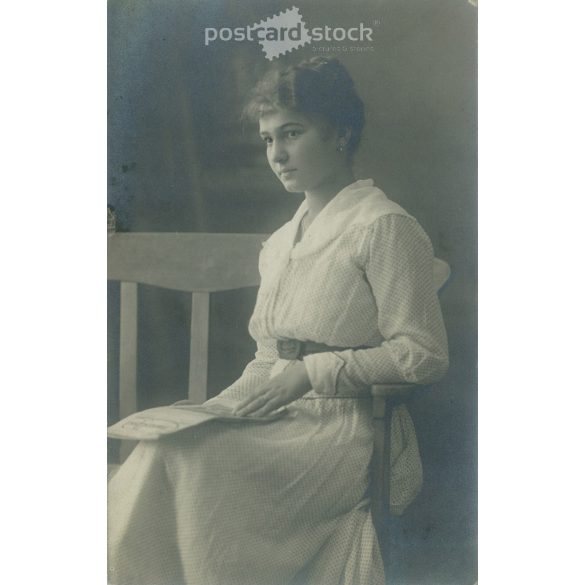 Young woman in white, studio shot. Gelatin silver. The person in the picture and the photographer are unknown. Original old photo. Black and white photo card, old postcard. (2793641)