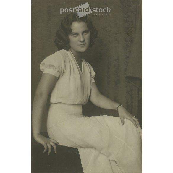 1968 - Young woman in white, studio shot. The person in the photo and the photographer are unknown. Original old photo. Black and white, laminated photo, original paper image. (2793645)