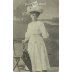   1910 - Young woman in summer clothes, studio shot. The person in the picture and the photographer are unknown. Original old photo. Black and white photo, old postcard. (2793648)