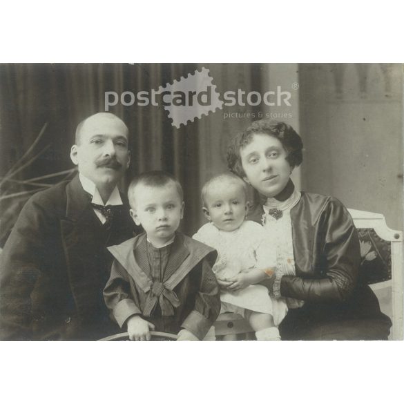 Family photo with children. The people in the photo and the photographer are unknown. Original old photo. Black and white, laminated photo, original paper photo. (2793650)