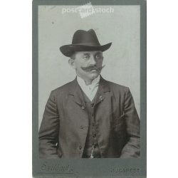   Circa 1900 - Hatter with badge, studio photo. The picture was taken in the photo studio of Jenő Szilágyi, Budapest. Old photo. Original cabinet photo / hardback photo / business card, CDV photo. (2793777)